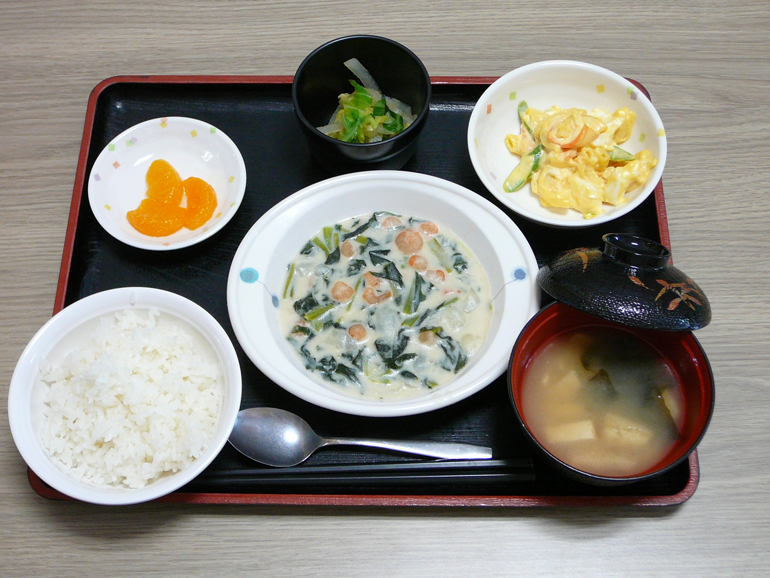 今日のお昼は エビと小松菜のミルク煮 卵サラダ 和え物 味噌汁 果物です
